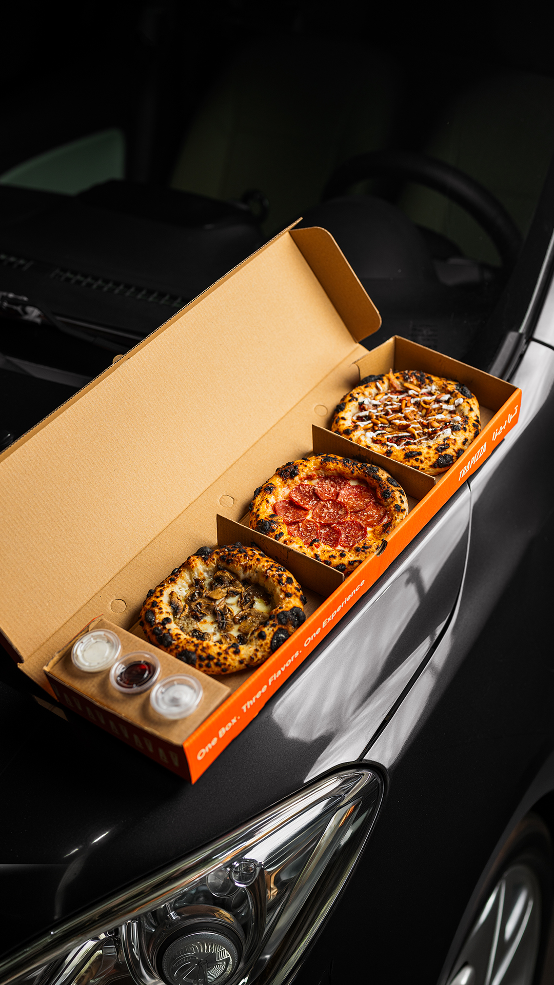 Trapizza box on a car hood